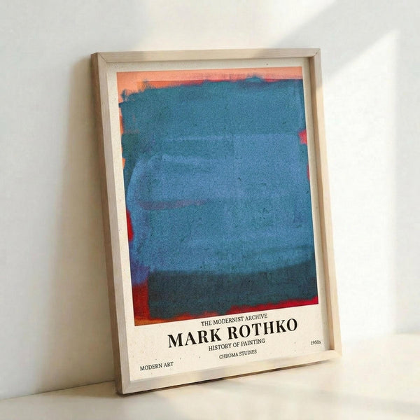 May include: Framed poster featuring abstract color field artwork with horizontal bands of blue and teal dominating the composition, accented by coral orange at the top and red elements along the edges. Text at bottom reads "THE MODERNIST ARCHIVE MARK ROTHKO HISTORY OF PAINTING CHROMA STUDIES 1950s MODERN ART". Light wood frame leaning against white wall corner, showing texture and grain of paper print.