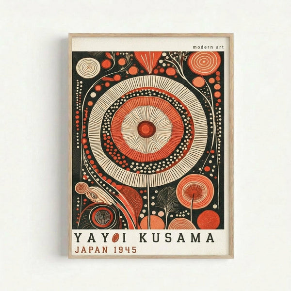 Framed art print featuring a large central mandala with concentric circles in red, cream, and black, surrounded by smaller circular and organic patterns. The geometric design uses dotted textures and radiating lines throughout. Text reads "YAYOI KUSAMA" and "JAPAN 1945" at bottom. Light wood frame against white wall background.