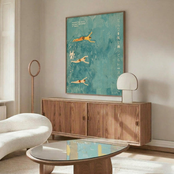 May include: Teal and turquoise poster showing three orange swimmers diving into stylized water with Japanese text on the right side, displayed above a mid-century modern walnut credenza in a minimalist living room with white walls, cream chair, oval glass coffee table, and warm natural lighting creating soft shadows.