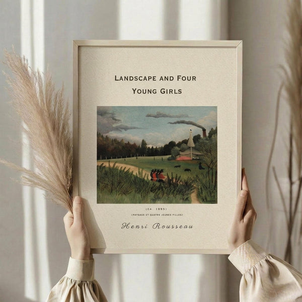 May include: Framed art print of Henri Rousseau's 1895 pastoral landscape painting showing rolling green fields, trees, small buildings with red roofs, and four small figures in the foreground. The poster features cream matting with black text identifying the artwork and artist. Person in beige clothing with ruffled sleeves holds the wooden-framed print while also holding dried pampas grass stems against a soft neutral background with window light.