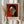 May include: Person in cream blouse holding framed art print against white curtained window, with dried pampas grass visible. The print features a stylized portrait of a woman with black hair and geometric facial features in green, orange, and red tones against a red background. White frame with text below the artwork including Henri Matisse attribution and French text.