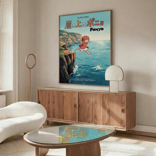 May include: Studio Ghibli Ponyo movie poster mounted on white wall above wooden sideboard in modern living room. Poster shows red-haired child jumping into blue ocean water from rocky cliff. Mid-century furniture includes walnut credenza, white curved chair, oval glass coffee table, and minimalist table lamps with warm lighting.