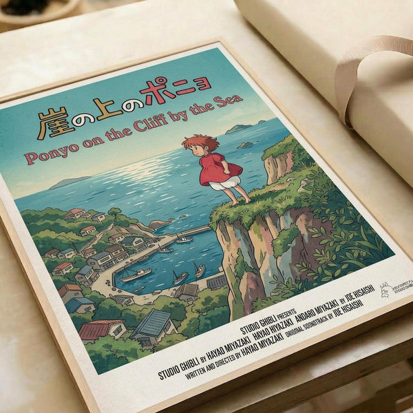 May include: Studio Ghibli Ponyo poster print displayed on white bedding. The vintage-style artwork shows young Ponyo in a red dress standing on a green cliff overlooking a coastal village with boats in the harbor below. Features Japanese and English text at top, with Studio Ghibli credits at bottom. Soft natural lighting illuminates the poster's turquoise sky and detailed landscape illustration.