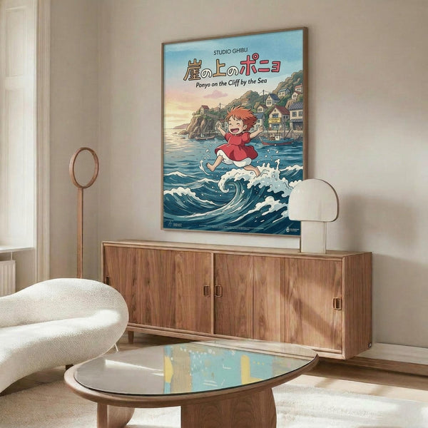 May include: Studio Ghibli Ponyo poster mockup in modern living room setting with wooden sideboard, white sculptural chair, and glass coffee table. Poster shows red-haired child character Ponyo running on ocean waves with coastal village background in blue, pink and coral tones. Thin wooden frame against cream walls with natural lighting.