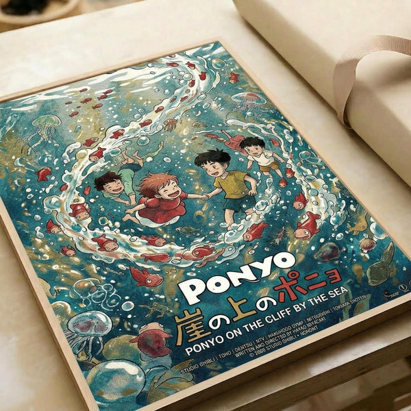 May include: Colorful anime-style poster featuring children swimming underwater surrounded by red fish, jellyfish, and sea creatures in swirling blue-green waters. The print shows Japanese text and lies flat on white paper with a roll of paper beside it on a light wooden surface. The artwork has a whimsical Studio Ghibli animation style with detailed ocean elements and bubbles throughout the aquatic scene.