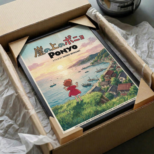 May include: Framed Ponyo movie poster print in wooden frame, packed in cardboard shipping box with protective tissue paper. Artwork shows young girl in red dress waving at seaside village with boats in harbor, rendered in Studio Ghibli's distinctive animated style with soft pastels and watercolor-like textures. Japanese text visible at top of vintage-style poster design.