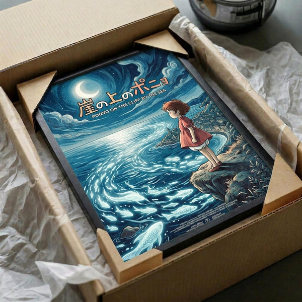 May include: Framed Studio Ghibli Ponyo poster in cardboard shipping box with protective white tissue paper. Artwork shows young girl in red dress standing on rocky cliff overlooking swirling ocean waves under starry night sky with crescent moon. Deep blues and teals dominate the scene with Japanese text at top. Frame appears black, nestled securely in brown cardboard packaging on wooden surface.