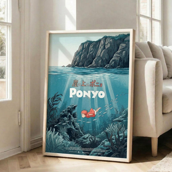 May include: Framed poster displayed in bright living room with beige armchair and white walls. Artwork shows underwater scene with red-haired character swimming among fish, sea plants, and rocky cliffs above water surface. Japanese text and "PONYO" title in white letters. Light wood frame, poster leaning against wall on hardwood floor.