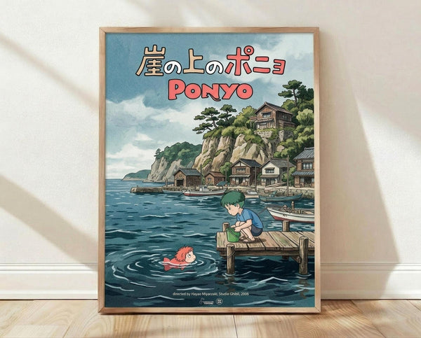 May include: Framed poster print leaning against white wall on light wooden floor. The artwork shows Studio Ghibli's Ponyo anime scene with green-haired boy sitting on wooden dock, red-haired girl swimming in blue water below. Japanese coastal village with traditional houses built into rocky cliffs visible in background under cloudy sky. Japanese text at top in beige and red lettering. Natural wood frame surrounds the colorful illustration in signature Miyazaki animation style.