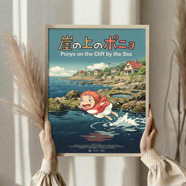 May include: Person holding framed poster showing animated red-haired boy character swimming in blue ocean water near coastal village with colorful houses on cliff. Japanese text at top with English subtitle. Poster has light wood frame, held against white curtained window with dried pampas grass visible on left side.