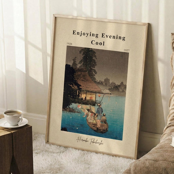 May include: Framed vintage Japanese woodblock print showing people in a boat on blue water near a thatched-roof house, with "Enjoying Evening Cool" text and dates 1926-1927. Print has cream matting in light wood frame, leaning against white wall next to white coffee cup on wooden block and beige knit blanket on white textured rug.