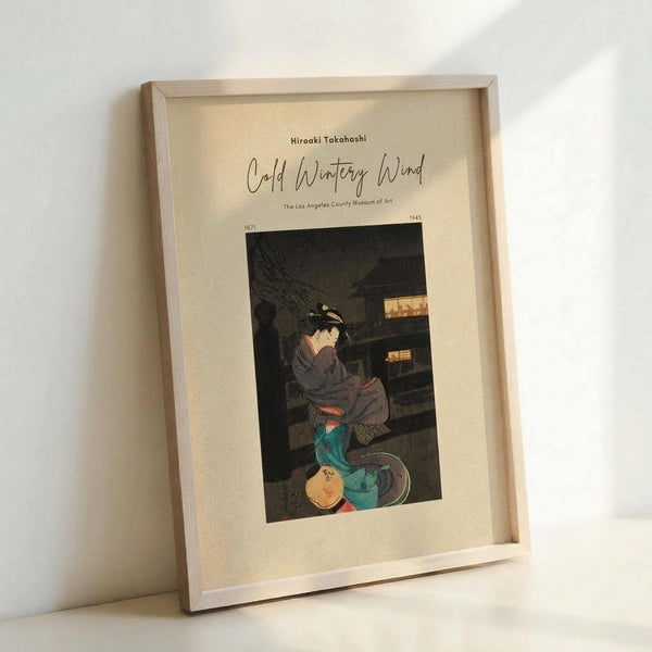 May include: Framed vintage Japanese woodblock print showing a woman in traditional dress sitting by illuminated buildings at night. The artwork features muted colors with pops of teal and yellow against dark tones. Light wooden frame with cream matting, positioned at an angle against white wall on white surface.