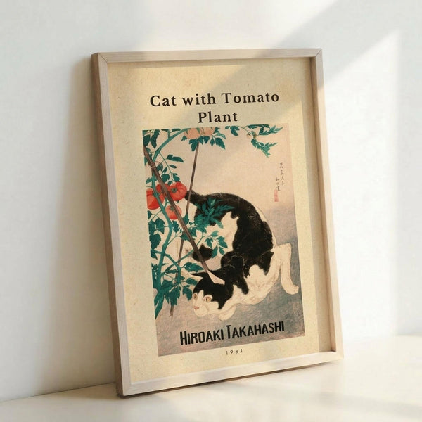 May include: Framed vintage Japanese art print showing a black and white cat sitting beneath a tomato plant with red tomatoes and green leaves. The artwork has a cream background with Japanese characters and "HIROAKI TAKAHASHI 1931" text at bottom. Light wood frame displayed against white wall, casting soft shadows.