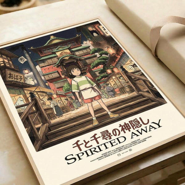 May include: Spirited Away movie poster print lying flat on white paper with cream ribbon nearby. Shows anime girl with short black hair in white and green striped shirt standing on wooden steps of traditional Japanese bathhouse at night. Detailed illustration features multi-story building with red and green architectural details, glowing lanterns, and Japanese text. Rich colors include deep blues, warm browns, and golden lighting.