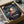 May include: Framed Spirited Away movie poster featuring young Chihiro in red shirt surrounded by white spirits against twilight landscape, displayed in cardboard shipping box with protective padding on neutral surface beside dark glass bowl