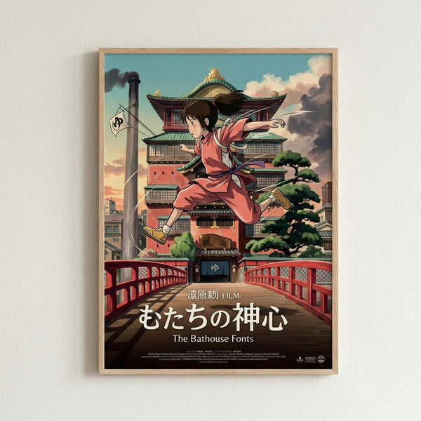 May include: Framed anime movie poster mounted on white wall. Features young girl in pink outfit leaping through air above traditional Japanese bathhouse with curved green roofs. Red bridge spans foreground, industrial smokestack visible left side. Artwork shows detailed architectural elements, cloudy sky backdrop in warm sunset tones. Natural wood frame surrounds colorful illustration with Japanese text and English subtitle at bottom.