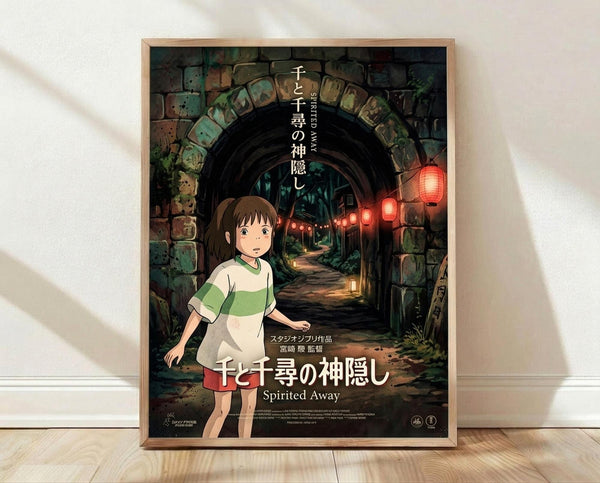 May include: A framed movie poster featuring a young girl with brown hair in a white and green striped shirt standing in front of a stone archway tunnel. Red paper lanterns hang along a mysterious pathway leading into darkness. The poster displays Japanese text at the top and "Spirited Away" at the bottom. The wooden frame sits on light wooden flooring against a white wall with soft natural lighting casting gentle shadows.