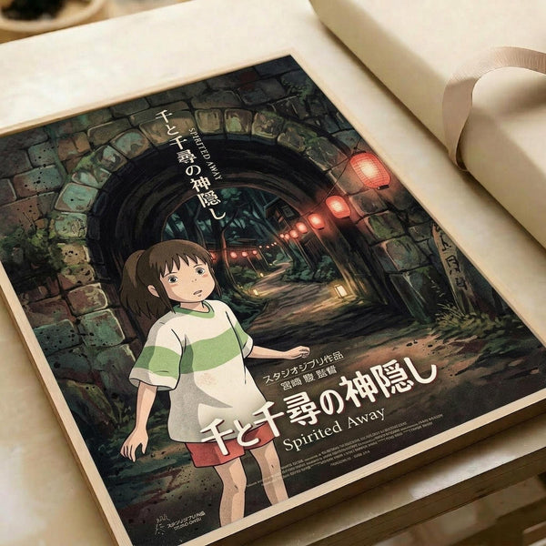 May include: A vintage-style movie poster featuring an animated young girl with brown hair in a green and white striped shirt, standing in front of a stone archway tunnel with glowing red lanterns. The poster displays Japanese text and "Spirited Away" in English at the bottom. The print is shown laying flat on white paper with a cream ribbon visible in the corner, creating an unboxing or gift presentation scene.