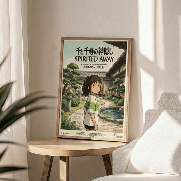 May include: Framed Spirited Away movie poster featuring anime girl with brown hair in green and white striped shirt standing in traditional Japanese garden setting with stone lanterns and pond. Poster displayed on round wooden side table next to beige upholstered chair with white throw pillow. Natural sunlight creates shadows on neutral wall behind frame.