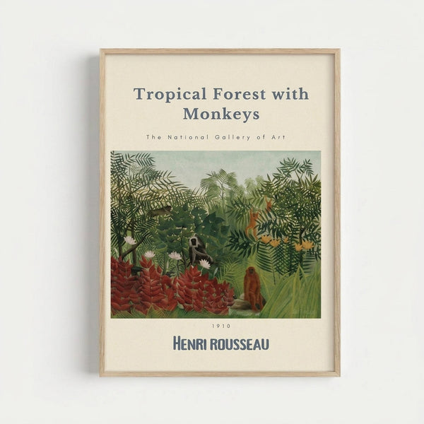May include: Framed art print of Henri Rousseau's jungle painting mounted on white wall. Shows dense tropical forest scene with lush green foliage, palm fronds, red flowering plants, and several monkeys among the vegetation. Light wood frame surrounds cream-colored mat with museum-style text above and below the artwork. Soft natural lighting creates gentle shadow on wall.