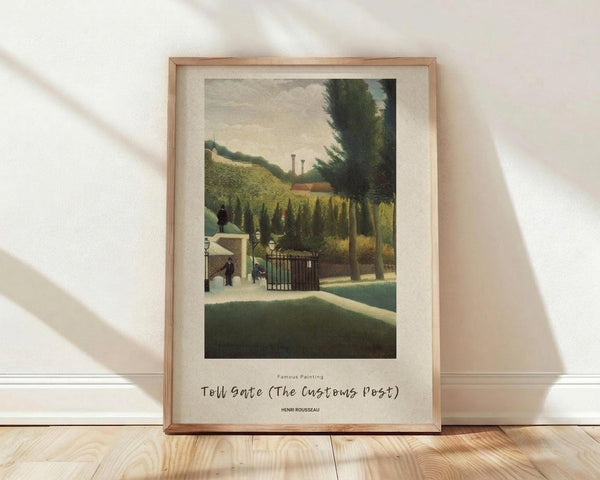 May include: Framed art print of Henri Rousseau's pastoral landscape painting featuring figures near a toll gate with cypress trees, rolling green hills, and industrial chimneys in the distance. The print has cream matting in a light wood frame, displayed against white textured walls on blonde hardwood floors with natural lighting casting soft shadows.