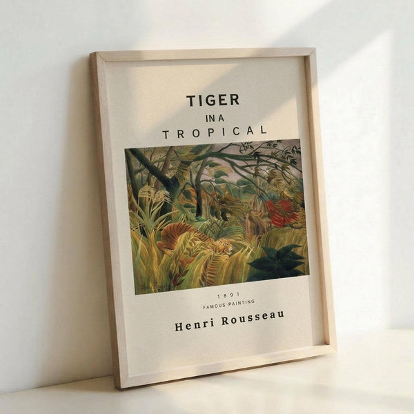 May include: Framed art print featuring Henri Rousseau's jungle painting with a hidden tiger among lush tropical foliage in greens, yellows, and oranges. White matting displays title "TIGER IN A TROPICAL" with artist name and "1891 FAMOUS PAINTING" below the artwork. Natural wood frame leans against white wall with soft shadows.