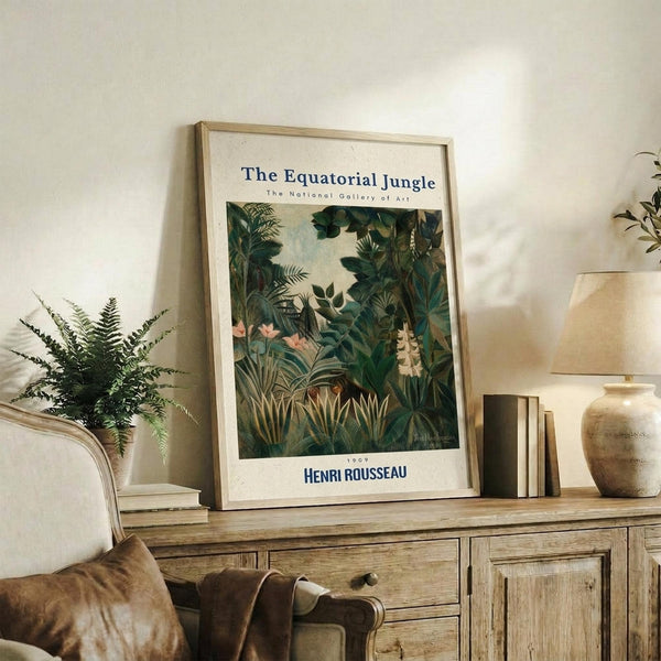 May include: Framed botanical art print featuring lush jungle foliage in deep greens with tropical plants and flowers, displayed on weathered wood sideboard alongside fern plant, ceramic vase, stacked books, and throw pillows in neutral living room setting with cream walls
