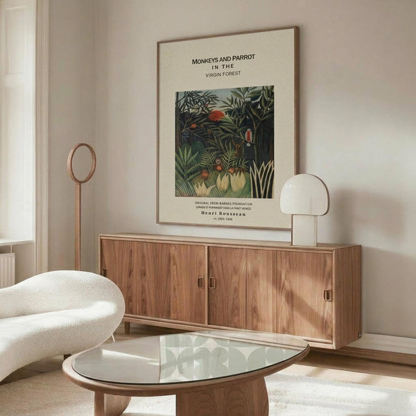 May include: Framed Henri Rousseau jungle print featuring monkeys and parrot among lush green foliage, displayed above walnut credenza in modern living room with white curved chair, glass oval coffee table, and minimalist decor. Print shows tropical birds in dense forest setting with museum-style text layout.