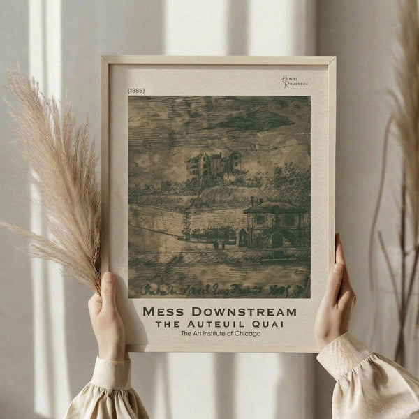 May include: Person in cream outfit holding framed art print showing muted green landscape scene with buildings and countryside, dried pampas grass in left hand, soft natural lighting by white curtained window, neutral beige wooden frame, vintage museum-style poster layout with artist signature and exhibition text below artwork