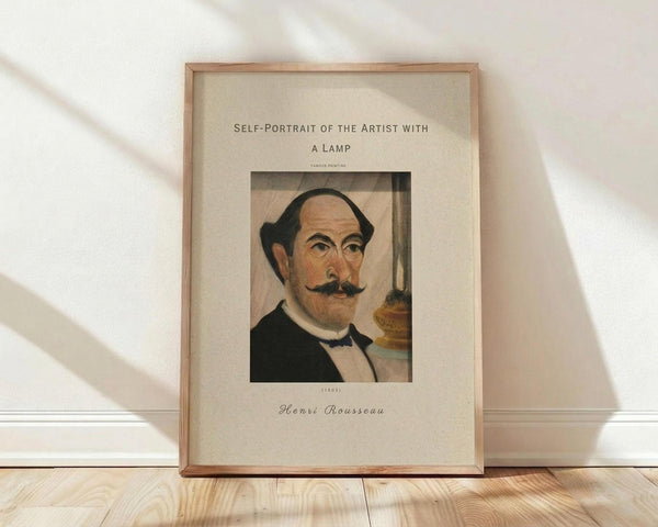May include: Framed art print of Henri Rousseau's self-portrait showing a balding man with dark mustache wearing formal black suit with bow tie, positioned next to an oil lamp. The vintage-style poster has cream matting with elegant typography above and below the image. Natural wood frame leans against white wall on light wooden floor with soft shadows from window light.