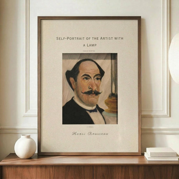 May include: Framed art print featuring Henri Rousseau's 1903 self-portrait showing a balding man with dark hair and mustache wearing formal black attire, displayed on a wooden credenza beside a white ceramic vase and stacked books against white paneled walls