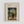 May include: Framed museum poster print featuring Henri Rousseau's painting of an elderly man in dark suit and bowler hat standing beside a small child in white dress under leafy trees in a park setting. The vintage-style art print has cream matting in a light wood frame against a white wall, showing naive art painting style with soft greens, earth tones, and gentle brushwork typical of early 1900s Post-Impressionist work.