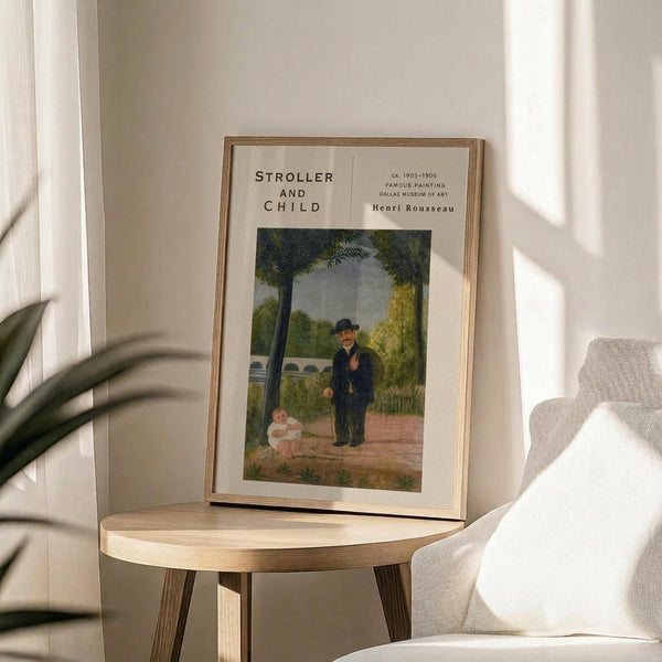 May include: Framed art print featuring Henri Rousseau's painting of a man in dark suit and hat standing near a small child in white dress within a lush green park setting. The poster has cream matting with black text reading "STROLLER AND CHILD" and museum details. Displayed in thin gold frame on round wooden side table next to white upholstered chair, with plant leaves casting shadows on neutral wall in bright natural light.