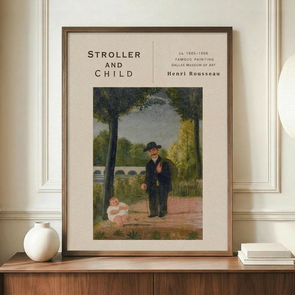 May include: Framed poster print of Henri Rousseau's painting showing an elderly man in dark clothing standing beside a baby in white sitting on the ground in a park-like setting with lush green trees. The cream-colored print is displayed in a thin brown frame on a wooden credenza alongside a white ceramic vase and small stack of books against white paneled walls.