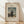 May include: Framed art print featuring Henri Rousseau's 1890 self-portrait showing a bearded man in black suit holding palette, standing before a landscape with buildings, bridge, and cloudy sky. The print has cream background with black text reading "MYSELF PORTRAIT LANDSCAPE" above the image and "1890 FAMOUS PAINTING Henri Rousseau" below. Natural wood frame sits against white wall on light wooden floor with soft shadows.