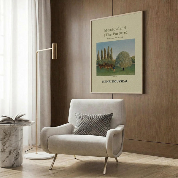 May include: Framed art print of pastoral landscape with cattle grazing near tall poplar trees and flowering bush, displayed on wood-paneled wall above modern beige armchair with geometric pillow. Golden floor lamp and marble side table with open book complete the contemporary reading nook setting.