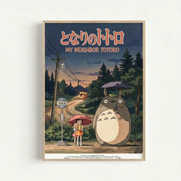 Framed poster featuring the iconic Studio Ghibli characters Totoro and two children waiting at a rural bus stop in the rain. The artwork shows a large gray forest spirit holding an umbrella standing next to two young girls, one holding a red umbrella, at a wooden bus stop sign surrounded by lush green trees. The scene depicts a dusky evening sky with power lines and a distant house, rendered in the classic hand-drawn animation style with warm earth tones and deep blues.