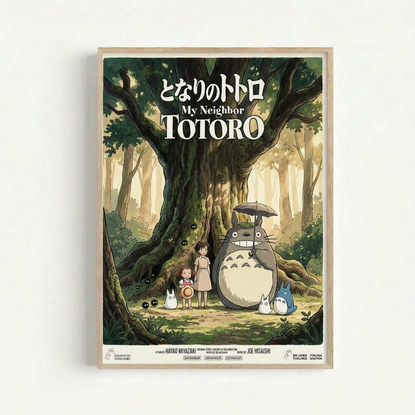 Framed poster featuring the beloved Studio Ghibli characters Totoro and forest spirits in a magical woodland setting. The artwork shows two children standing beside the large gray Totoro creature under a massive tree, with smaller white spirits nearby. Rendered in soft greens and earth tones with dappled sunlight filtering through the forest canopy. Japanese and English text appears at the top. The poster is displayed in a light wooden frame against a white wall.