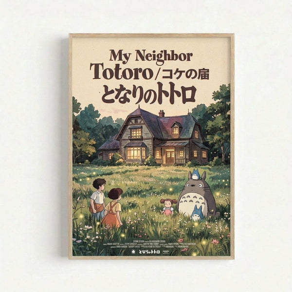 Framed movie poster featuring the beloved forest spirit Totoro and two children in a lush green meadow with wildflowers. A cozy wooden house with glowing windows sits among trees in the background. The artwork displays warm earth tones and whimsical Studio Ghibli animation style, with Japanese and English text at the top. The poster is mounted in a light wooden frame against a white wall.
