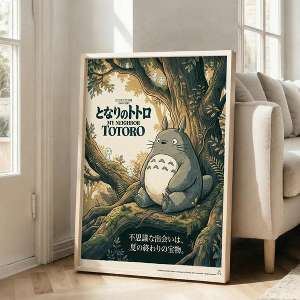 May include: Framed My Neighbor Totoro poster leaning against white wall next to beige armchair in bright room with windows. Shows large gray Totoro character sitting in forest tree surrounded by small white spirits, with Japanese text and earthy green and brown tones throughout the vintage-style artwork.