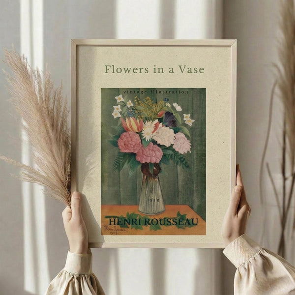 May include: Person holding framed vintage botanical print featuring colorful flowers in striped vase against sage green background, while holding dried pampas grass stems. Print shows pink peonies, white daisies, and yellow blooms in cream matted frame. Soft natural lighting with white curtains and neutral clothing create minimalist styling scene.