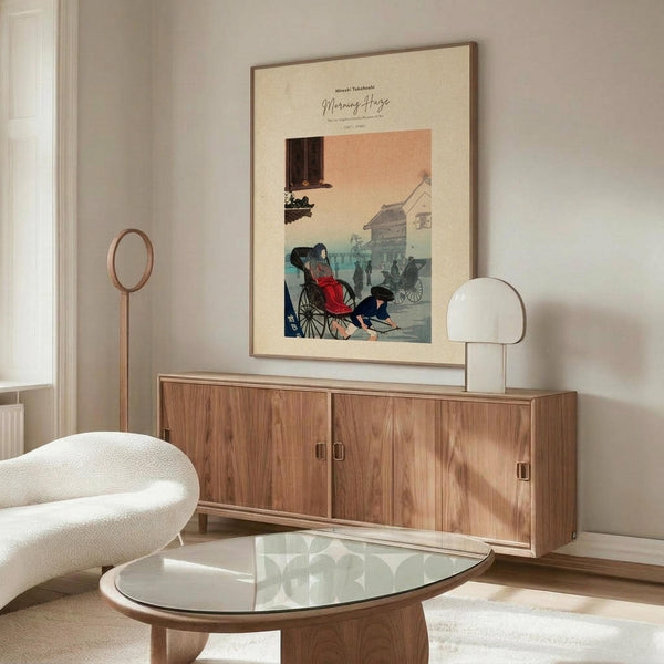 May include: Japanese woodblock print poster displayed in modern living room with cream walls, wooden sideboard, white curved chair, glass coffee table, and floor lamp. The vintage artwork features figures in traditional dress near rickshaws with warm coral and teal colors in an aged cream matted frame.