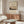 a living room with a large framed poster of Mount Fuji hanging on the wall, a wooden cabinet, a white sofa, and a glass coffee table.