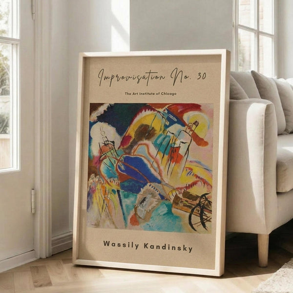 May include: Large framed art print leaning against white wall next to beige sofa in bright living room. Abstract colorful artwork features swirling blues, yellows, reds, and greens with dynamic brushstrokes and geometric elements. Cream matting with gallery-style text layout in light wood frame. Natural lighting from tall windows creates soft shadows on hardwood floors.