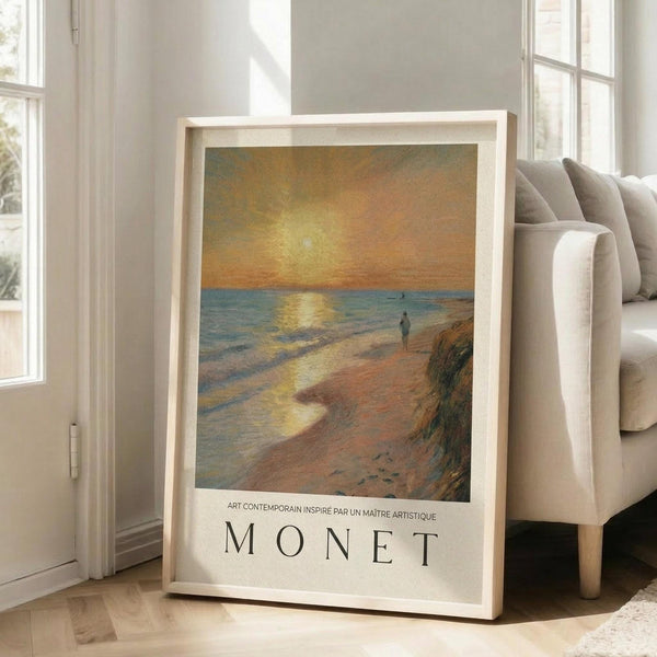 May include: Framed art print displayed in bright living room corner beside beige sofa. The poster features an impressionist seascape painting with golden sunset over water, small figure walking on beach, and "MONET" text below. Light wooden frame, cream matting. Sunlight streams through tall white windows onto hardwood floors.
