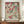 May include: A framed reproduction of a traditional Japanese woodblock print showing cherry blossoms and willow branches with sparrows and a swallow. The artwork features pink flowers, green foliage, and birds in classic ukiyo-e style with Japanese text. The print is displayed in a thin brown frame on a wooden credenza alongside a white ceramic vase and stacked books in a bright, modern room with white walls and molding.