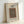 May include: Framed poster print leaning against white wall showing ornate carpet design with intricate floral patterns in blues, oranges and browns. Features decorative border and text reading "Holland Park Carpet Famous Pattern 1834-1896" and "William Morris The Met Museum" on cream background in light wood frame.