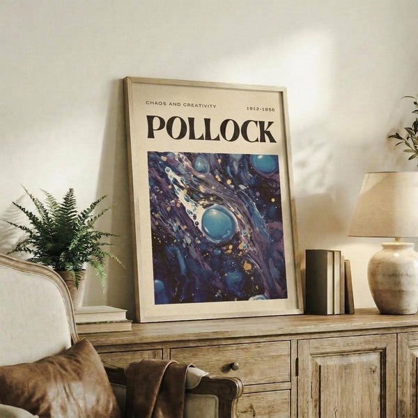 May include: Framed art print with "POLLOCK" text and cosmic blue abstract artwork featuring swirling galaxies and celestial orbs, displayed on rustic wooden console alongside fern plant, ceramic vase, and stacked books in modern living room setting with beige armchair