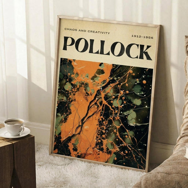 May include: Framed art poster leaning against white wall corner featuring abstract expressionist painting with vibrant orange, dark green, and black paint splatters and drips. Wooden frame, cream matting with "CHAOS AND CREATIVITY POLLOCK 1912-1956" text. Small wooden side table with white coffee cup and saucer nearby, beige textured rug below.