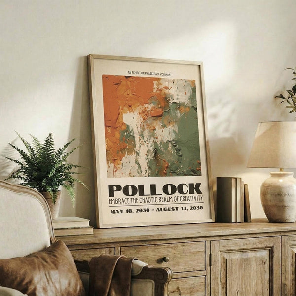 May include: Framed abstract art exhibition poster with orange, green and white paint textures displayed on rustic wooden sideboard next to fern plant, ceramic vase, and books in warm-toned living room setting with beige chair and lamp